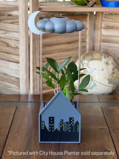 Stormy dripping rain cloud by THE CLOUD MAKERS with glow in the dark moon charm in city house planter